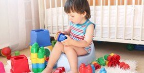 Potty training toddler playing with blocks